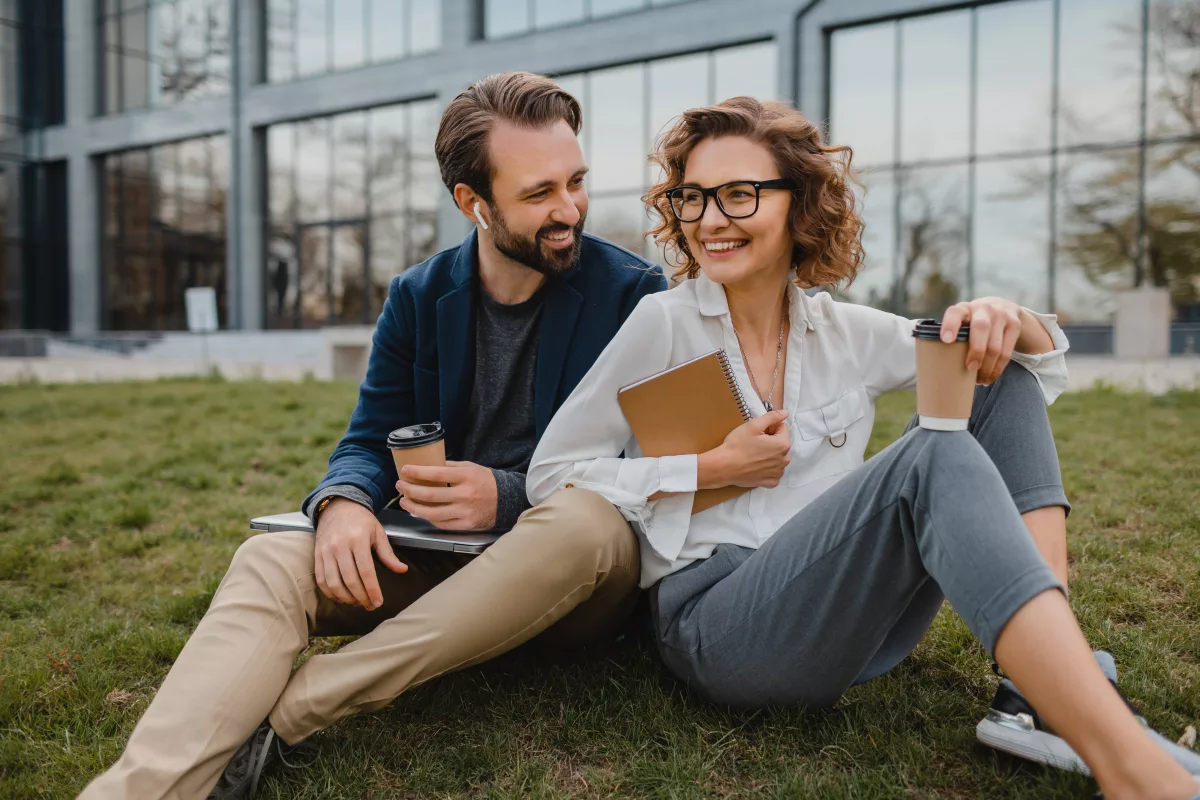 Príjemný kolektív v msg life Slovakia – msg life Slovakia dvaja kolegovci sedia na tráve a bavia sa