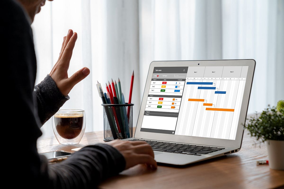 IT project manager is checking the project timeline on a laptop