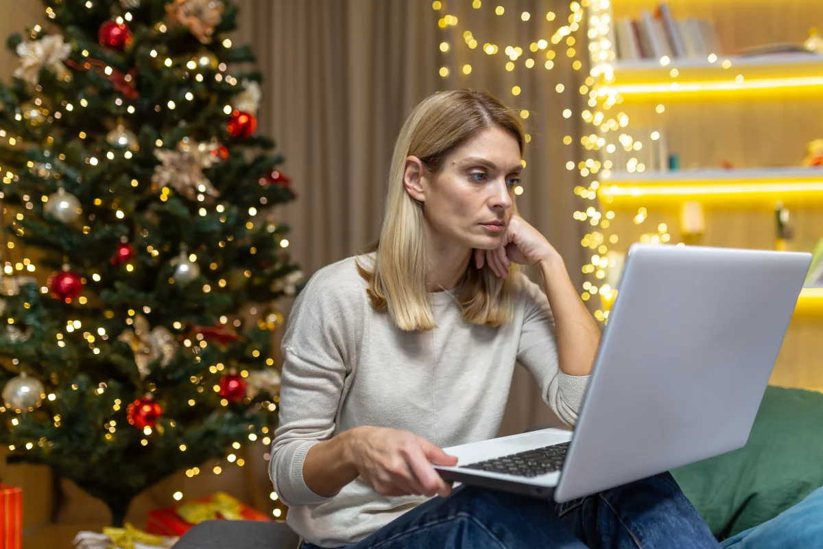 IT manager looking at her laptop by the Christmas tree